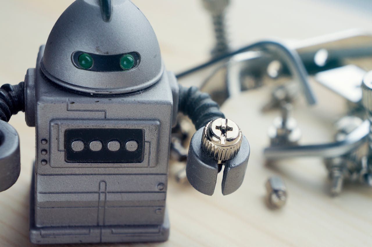 Detailed view of a toy robot holding a metallic screw, surrounded by tools.